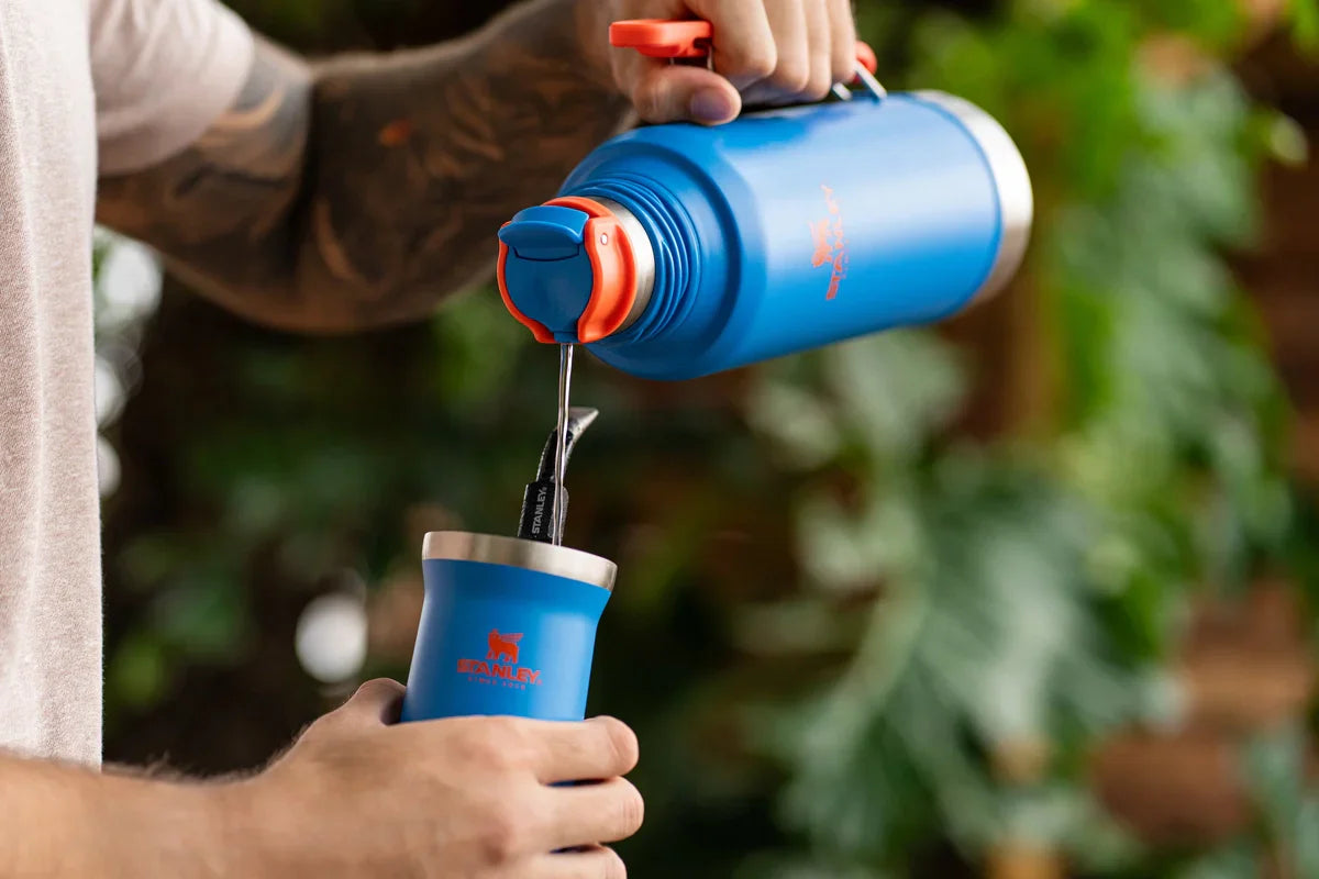 Uma pessoa usando uma garrafa e cuia Stanley para se aquecer durante os dias de inverno onde estiver.