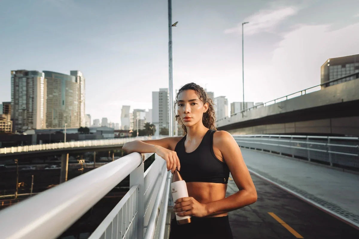 Uma mulher segurando uma garrafa carregando os sabores do Brasil com ela.
