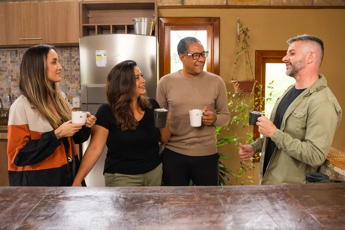 Quatro amigos lado a lado tomando um café e aproveitando a transição do outono para o inverno.
