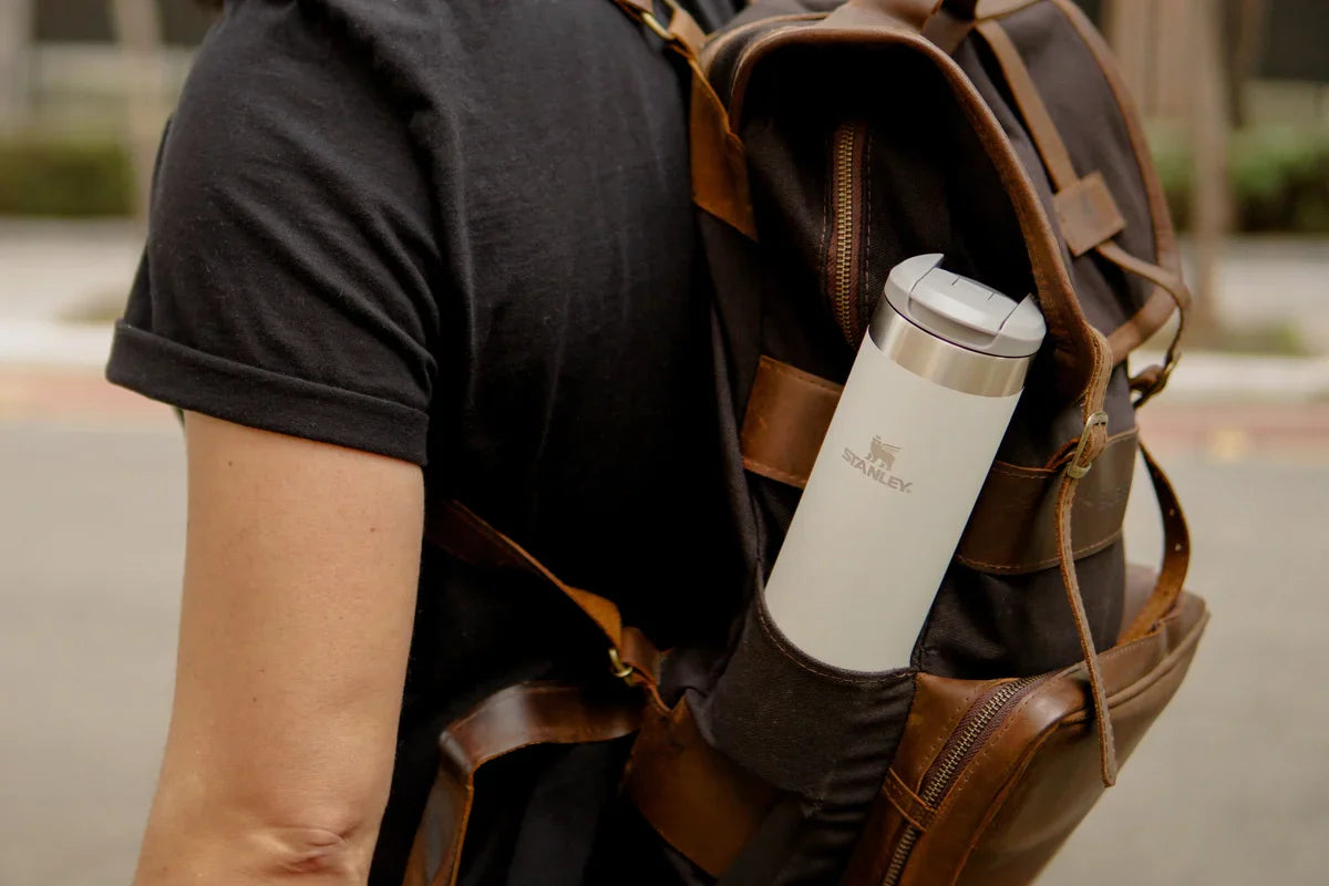 Um homem com sua mochila e garrafa Stanley, pronto para as viagens de inverno.