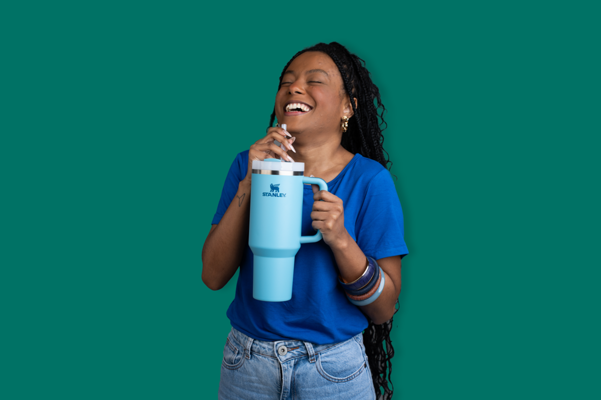 Uma mulher feliz segurando o Quencher, segurando por saber como cuidar do copo Stanley