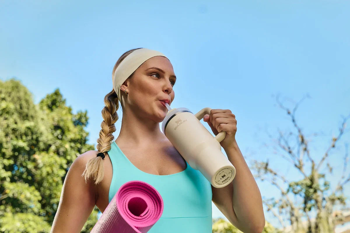 Uma mulher bebendo água na Quencher, fazendo uma hidratação inteligente.