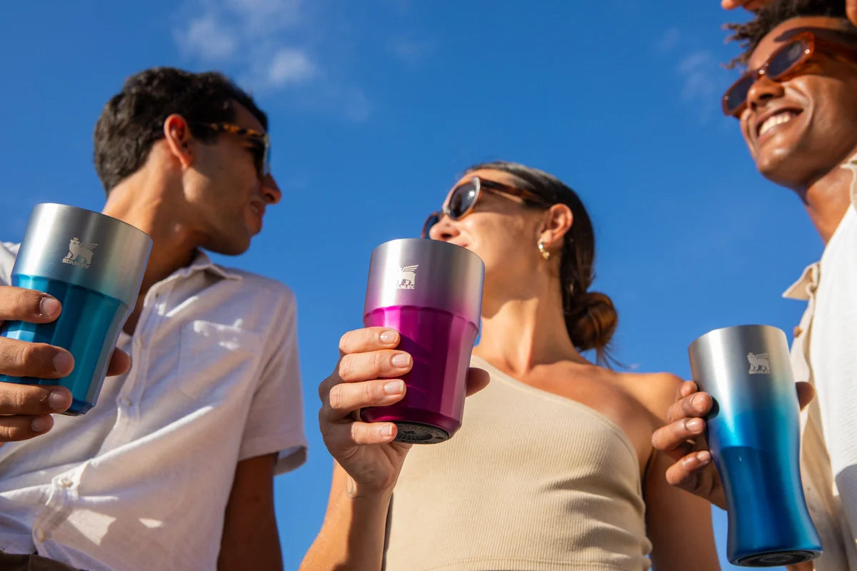 Três pessoas brindando com as novas cores do Beer Tumbler e do Pilsner Glass Stanley