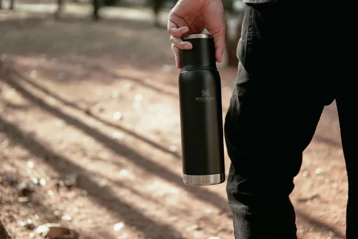 Uma pessoa segurando uma garrafa Stanley enquanto visita os destinos mais frios do Brasil.
