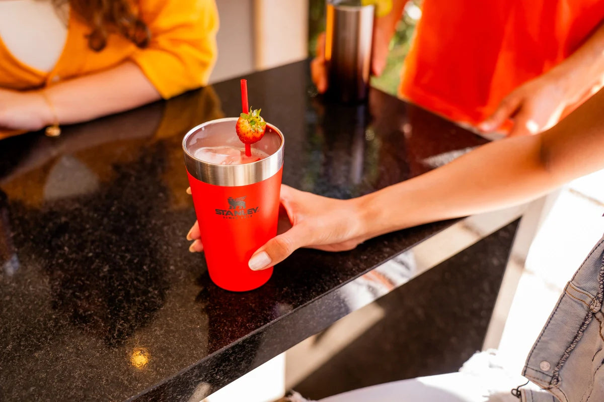 Uma pessoa bebendo um drink decorado, respondendo se pode colocar frutas no copo Stanley.